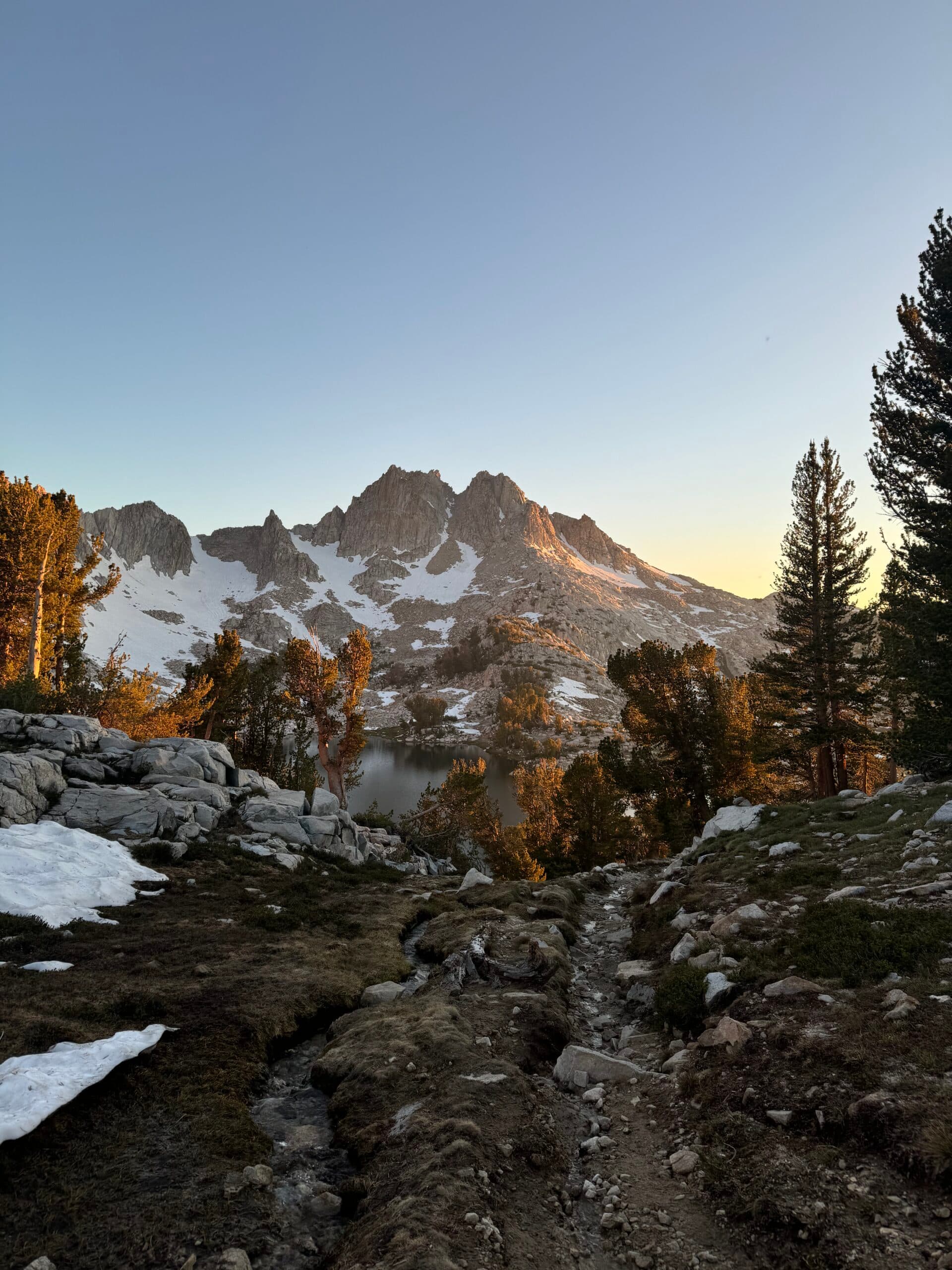 Alpine lake and forested mountains along the Pacific Crest Trail at sunset